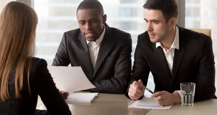 Recrutadores multirraciais entrevistando uma candidata.