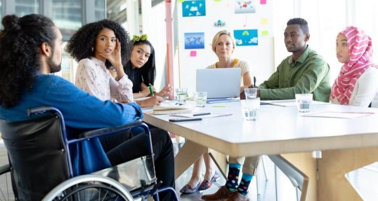 Diversidade na empresa representada por pessoas de todas as etnias em uma reunião.