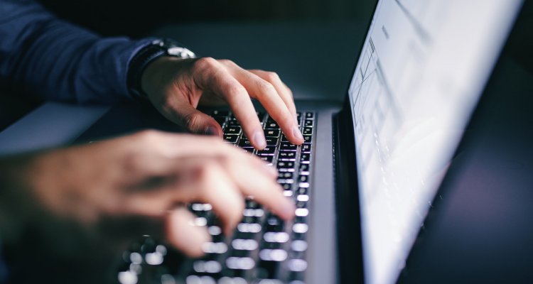 Mãos de um executivo digitando num laptop