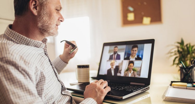 Executivo de meia idade participa de uma videochamada pelo notebook